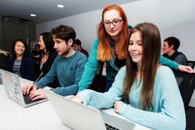 People sitting at MacBooks learning to code at CodeClan