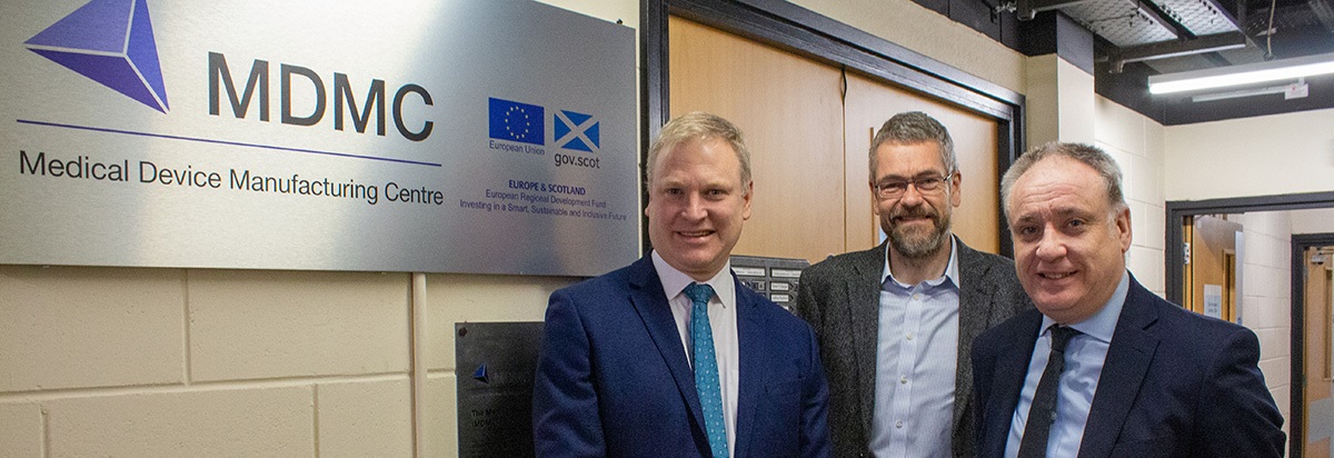 Richard Lochhead and Heriot-Watt University academics posing beside sign