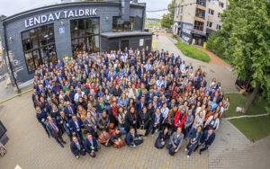 A large group of people face the camera smiling.
