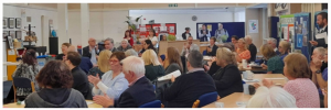community event with audience in groups clapping