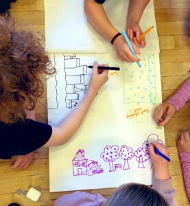 Children drawing on a sheet of paper