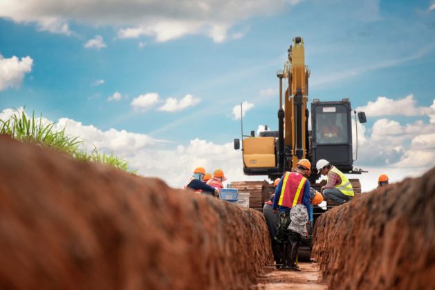 Yellow digger and workers on a construction site