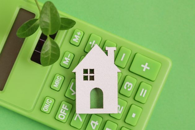 Green calculator and small white house