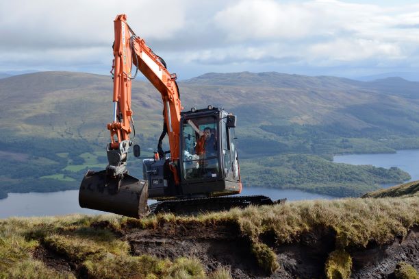 An orange digger operative works to reprofile a peat hag at Beinn Dhuand Mid Hill restoration site Image credit: ©Lorne Gill/NatureScot