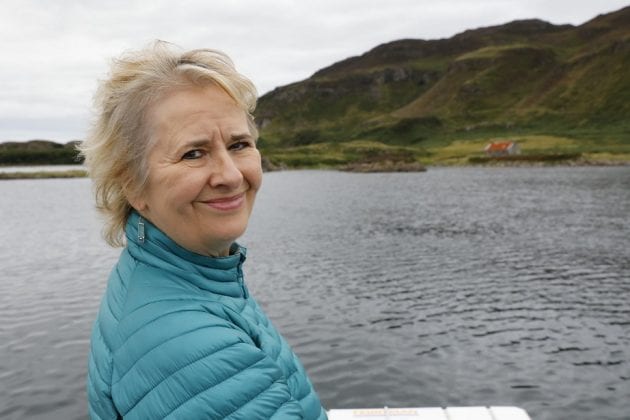 An image of Roseanna Cunningham by a lake with hills in the background.